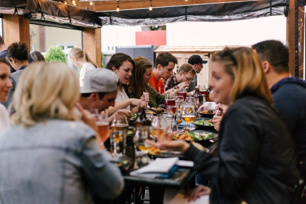 People sitting in front of a table while eating and talking